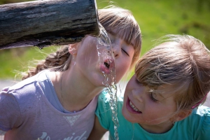 Kinder beim Trinken von Quellwasser